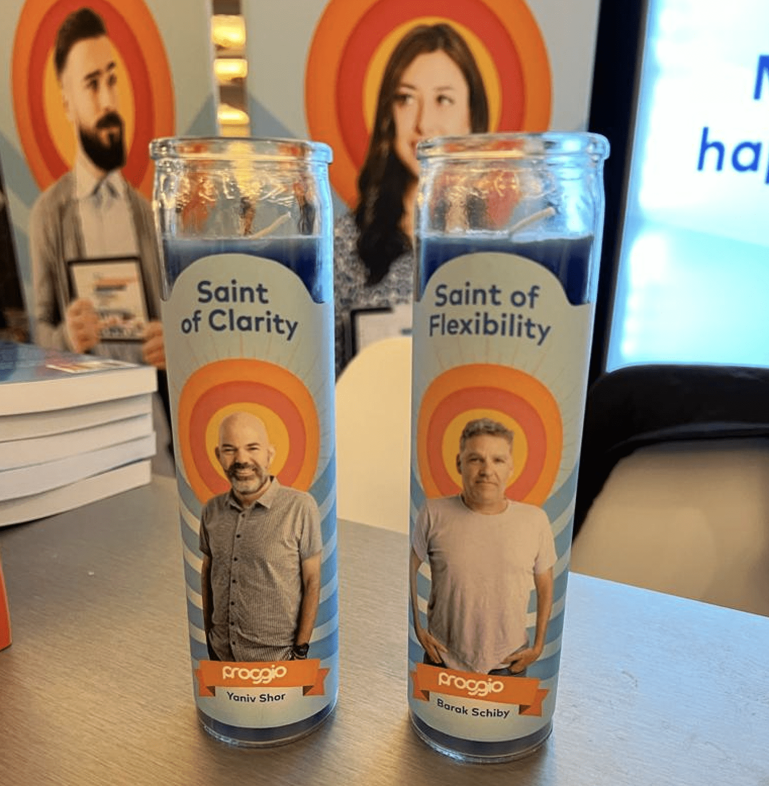 Two decorative candles labeled "Saint of Clarity" and "Saint of Flexibility" on a table.