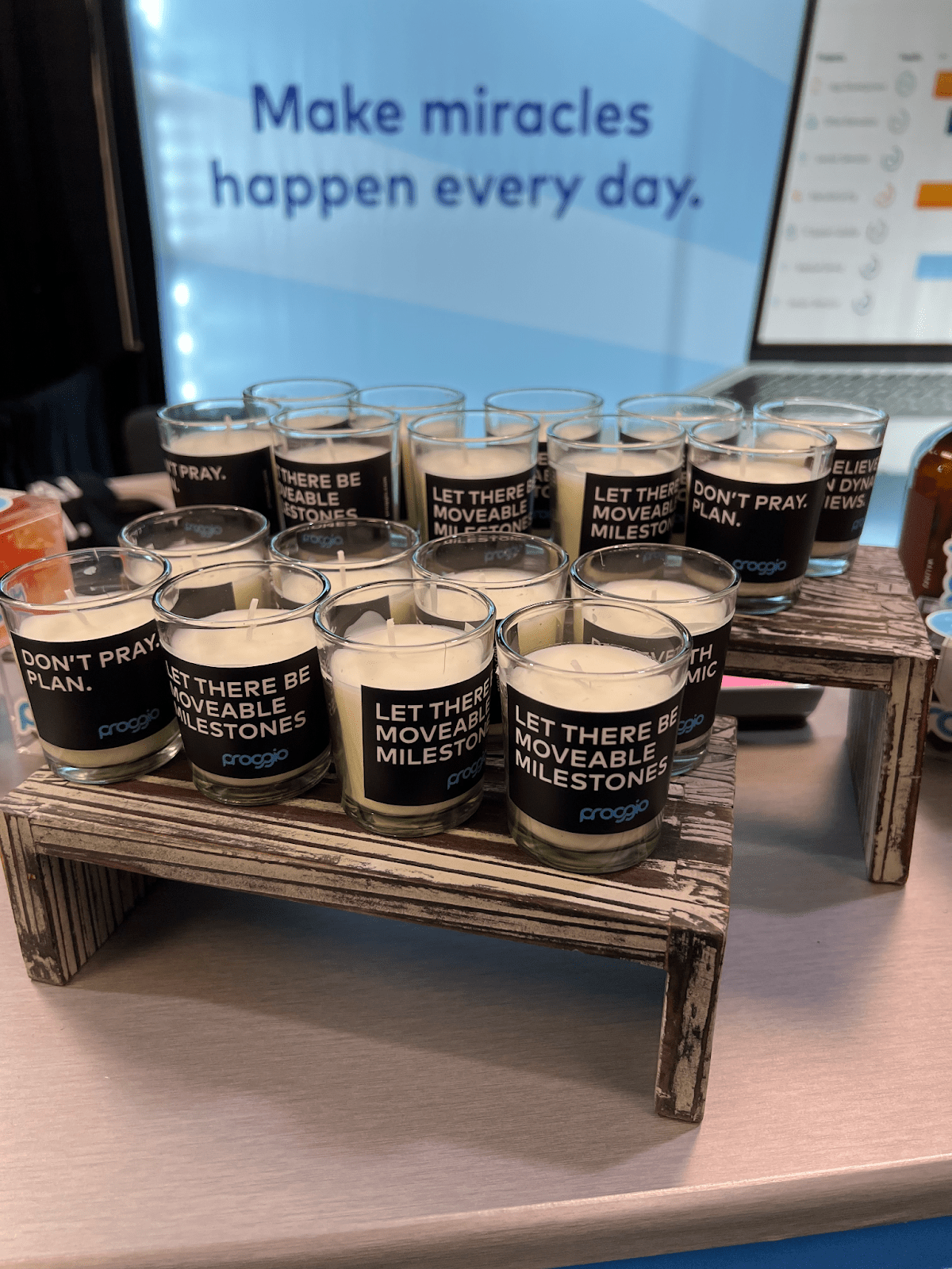 Candles on display with motivational quotes, under "Make miracles happen every day" sign.