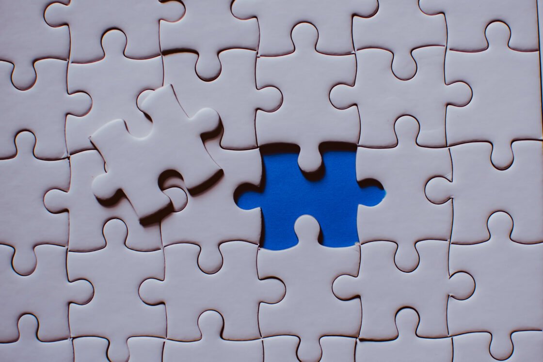 White puzzle with one piece missing, revealing a blue background underneath.