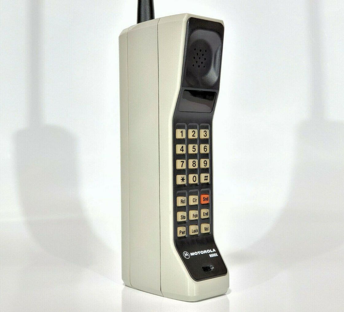 Vintage Motorola mobile phone with a keypad and antenna on a plain background.